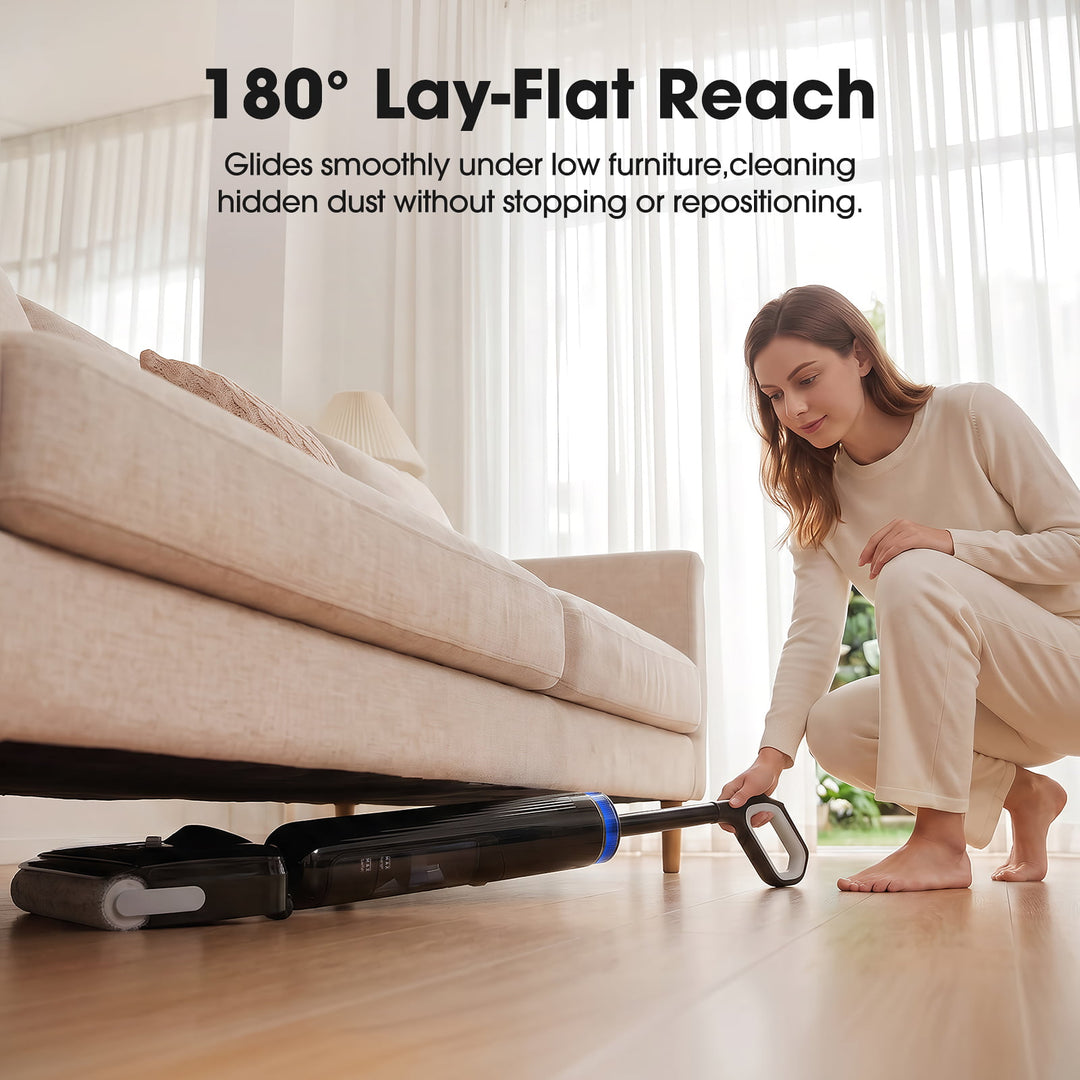 Woman using a vacuum cleaner with '180° Lay-Flat Reach' feature under a couch.